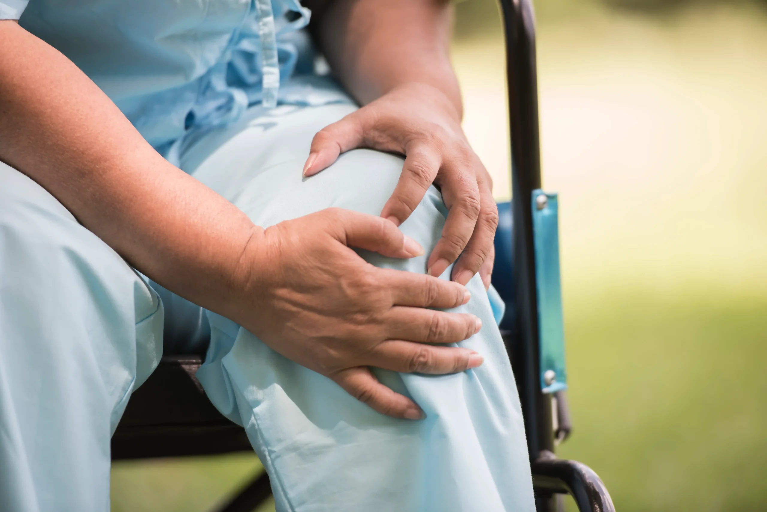 elderly woman sitting wheelchairs with knee pain compressed scaled